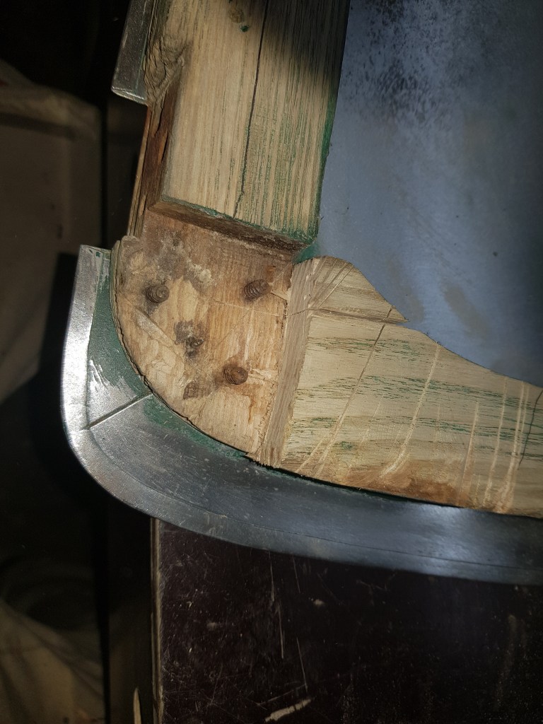 carefully using a hand saw and a chisel to remove the old wood - but keeping the screws and nails